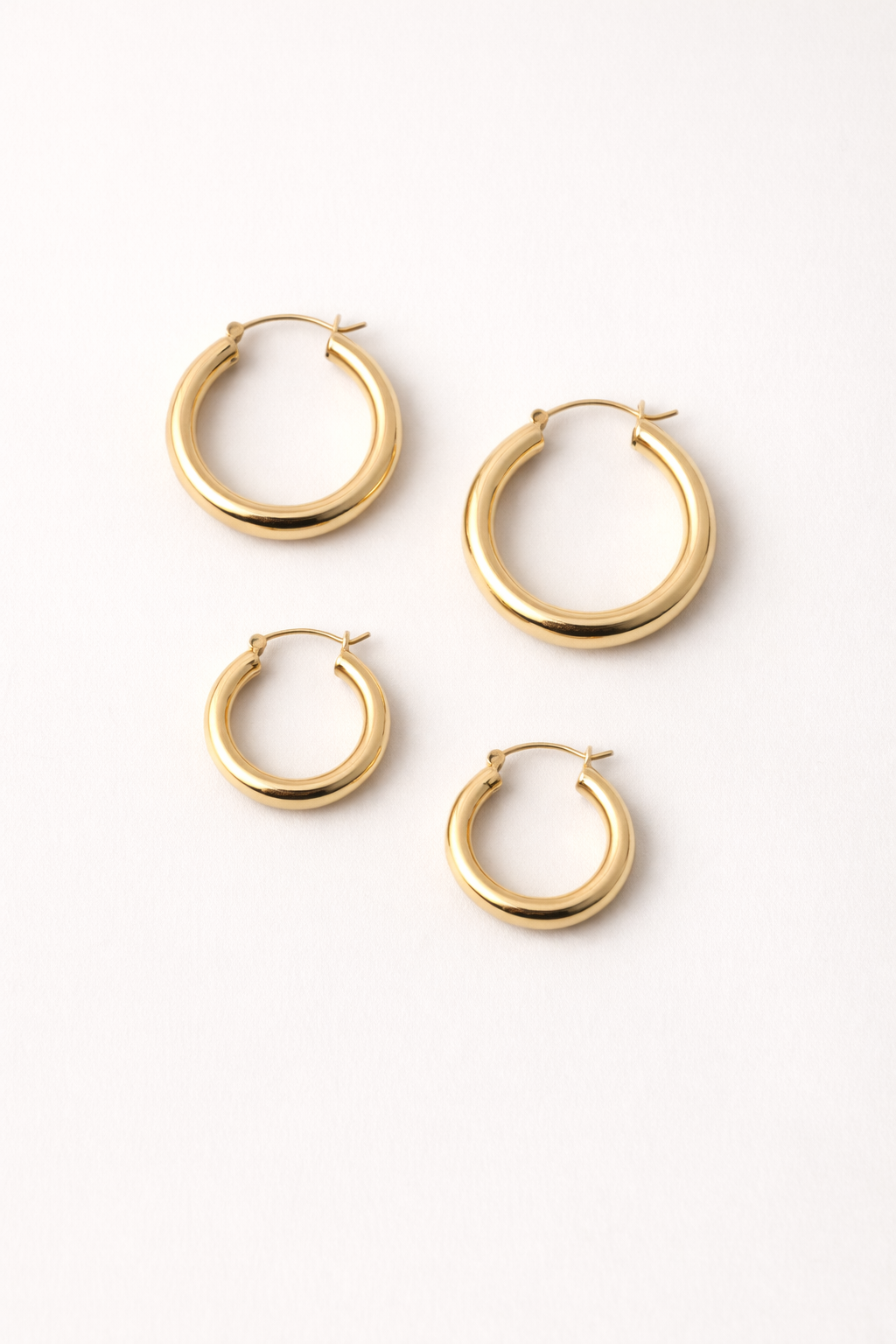 Voura gold hoop earrings set 3 pairs small medium large white studio background